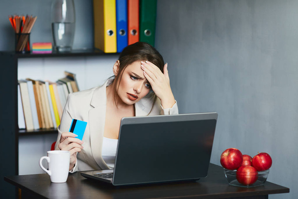 молодая деловая женщина с кредитной картой сидит на рабочем месте с ноутбуком
 - Фото, изображение