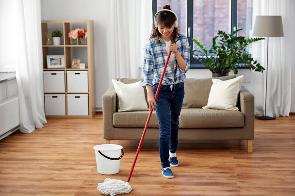 happy asian woman with mop cleaning floor at home - Fotoğraf, Görsel