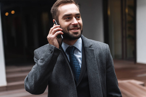 Attractive young businessman wearing suit walking - Fotografie, Obrázek