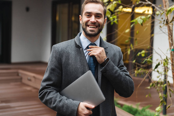 Attractive young businessman wearing suit walking - Zdjęcie, obraz