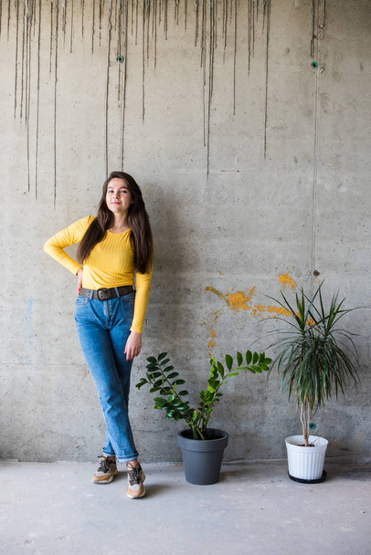 Nuori nainen keltainen pusero ja sininen farkut
 - Valokuva, kuva