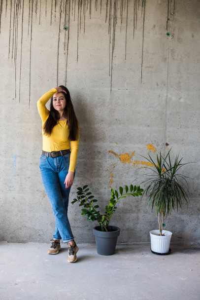 Jovencita en blusa amarilla y jeans azules
 - Foto, imagen