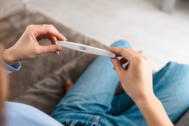 Happy young woman holding pregnancy test - Фото, зображення