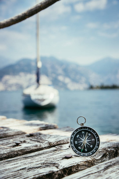 Sailing: nautical compass on wooden dock pier. Sailing boats in  - Foto, imagen