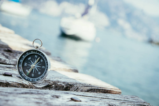 Sailing: nautical compass on wooden dock pier. Sailing boats in  - Fotó, kép
