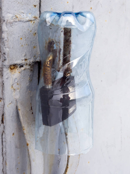 Protéger un cadenas contre la pluie avec une bouteille en plastique
 - Photo, image