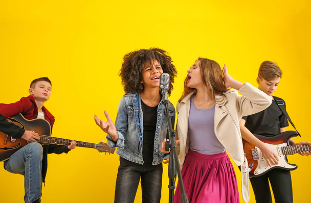 Teenage musicians playing against color background - Φωτογραφία, εικόνα