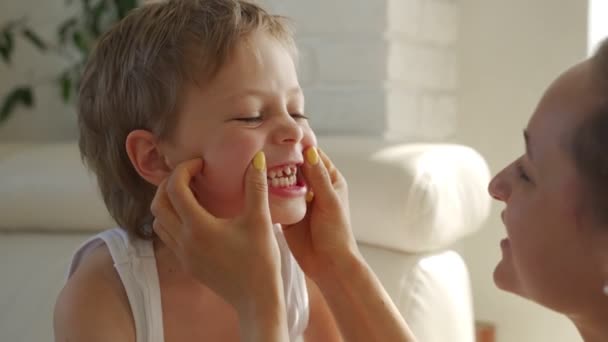 6 year old boy eating green apple and try pull out baby teeth - Séquence, vidéo