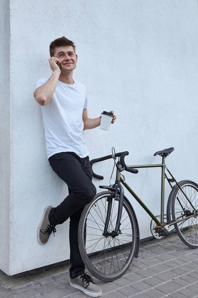 Handsome hipster man posing with bicycle in the city. - Zdjęcie, obraz