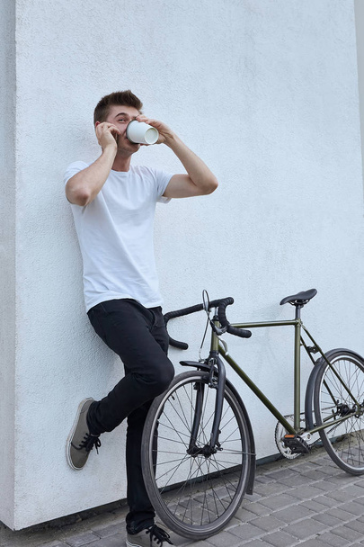 Hombre hipster guapo posando con bicicleta en la ciudad
. - Foto, Imagen