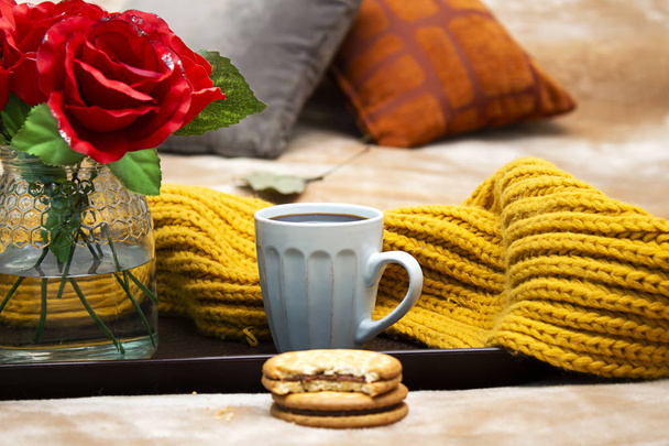 cup of coffee,  chocolate cookies and red roses flowers vase  in tray during the morning above brown bed - Photo, Image