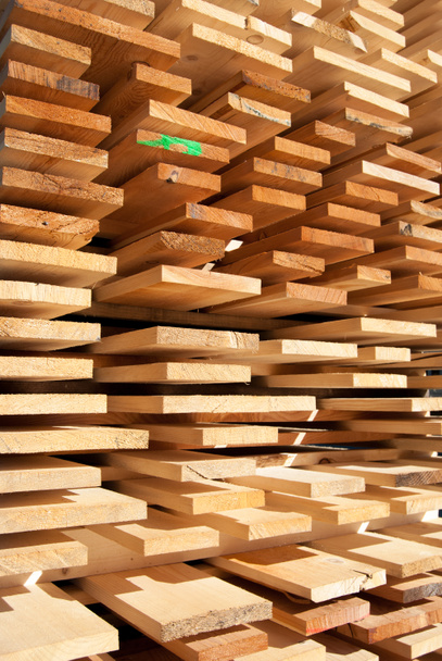 Wooden boards stacked neatly outside an industrial joinery - Fotoğraf, Görsel