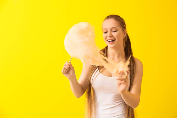 Beautiful woman with cotton candy on color background - Фото, зображення