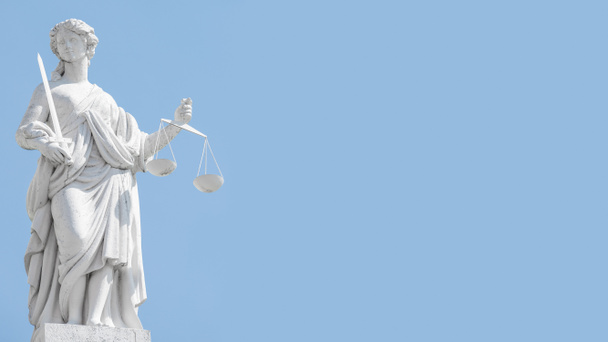 Posąg sędziego kobietę z łuskami i mieczem na błękitnym niebie w Donidzie - Zdjęcie, obraz