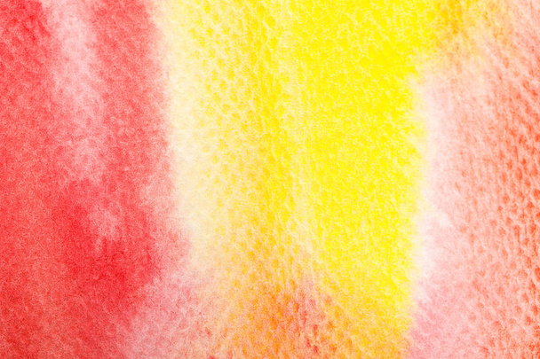 close up view of yellow and red bright watercolor paint spills on textured background - Foto, afbeelding