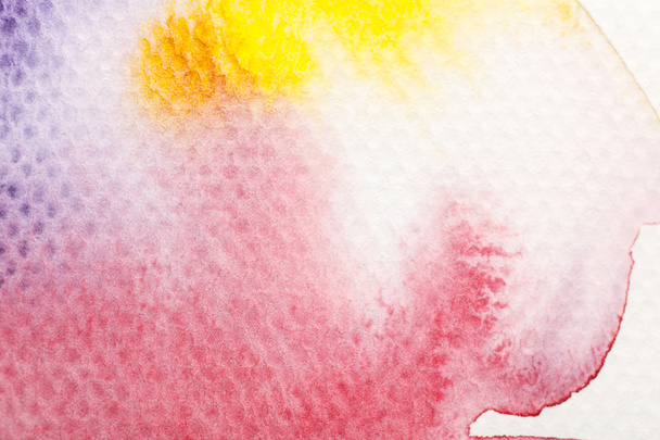 вид зверху на жовтий, фіолетовий і червоний акварельні бліді фарби розливаються на білому тлі
 - Фото, зображення