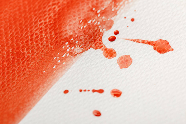 close up view of red watercolor paint brushstroke with drops on white textured background  - Foto, Imagem