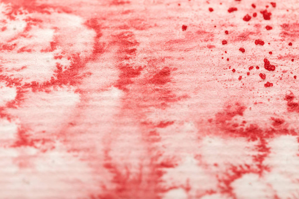 close up view of red colorful watercolor paint spill on textured paper background - Φωτογραφία, εικόνα
