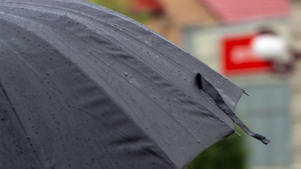 Ludzie ukrywają się przed deszczem pod parasolami w deszczowy dzień na ulicy miasta koncepcja zła pogoda - Zdjęcie, obraz