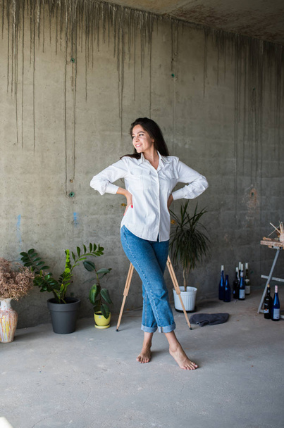 Linda jovem artista em camisa branca dançando descalça em seu loft estúdio artístico boêmio
 - Foto, Imagem