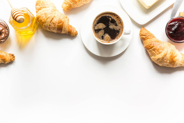 French freshly baked croissants and cup of coffee on white . Space for text. - Fotografie, Obrázek