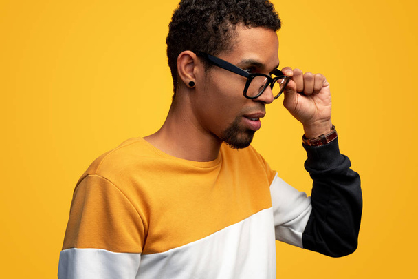 Thoughtful black male adjusting glasses - Foto, Imagem