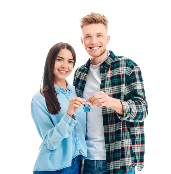 Young couple with key from their new house on white background - Foto, Imagen