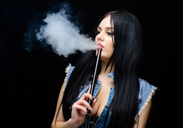 Hookah bar. Electronic cigarette. Fashion girl vaping. White cloud of smoke. Vaping is sexy. Nicotine addiction. Glamorous brunette smoking vaping device black background. Girl vaping. Rest and relax - Foto, immagini