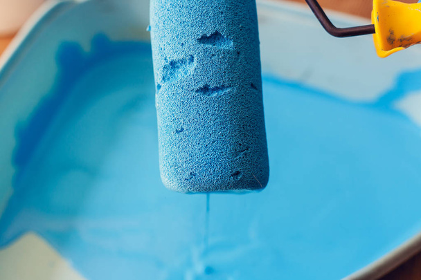 Foam roller in blauwe verf close-up. Reparatie en schilderen binnenshuis - Foto, afbeelding