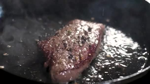 sappige verrukkelijke steak van marmer Houdini. Gebakken in een pan en olijfolie. Spatten van kokende olie en veel stoom. - Video