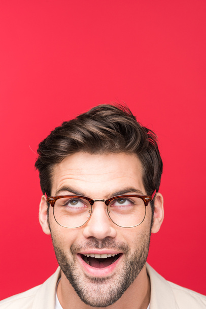 Überraschter schöner Mann mit Brille schaut isoliert auf rosa - Foto, Bild