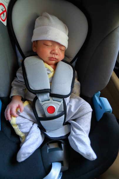 bébé nouveau-né mignon dormant dans le verrouillage de ceinture de sécurité de siège auto
 - Photo, image