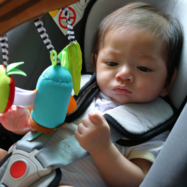 ребенок, сидящий в автокресле с заблокированным ремнем безопасности
 - Фото, изображение