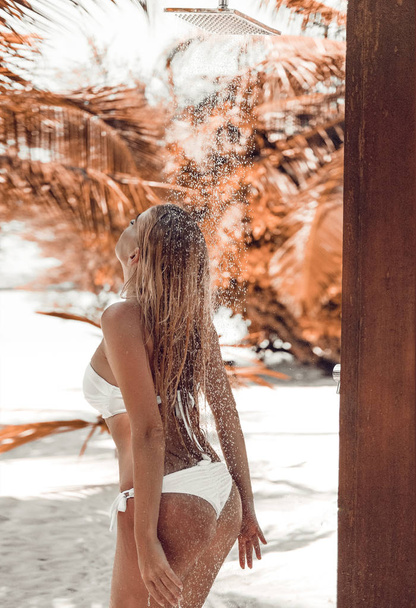 Wet sexy bikini female enjoying outdoor tropical shower at Maldi - 写真・画像