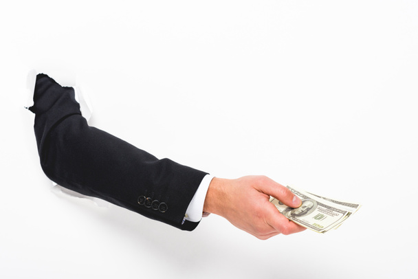 Обрезанный вид человека, держащего деньги через отверстие в бумажной стене на белом
 - Фото, изображение