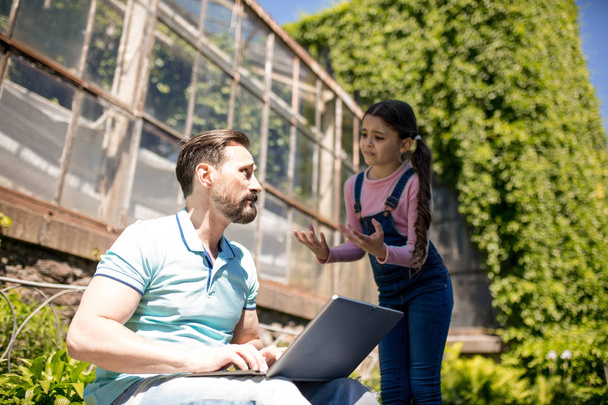 Father with daughter with laptop in park - Photo, Image