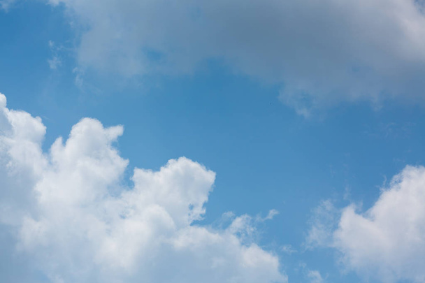 澄んだ青空の背景の上にふわふわの白い雲 - 写真・画像