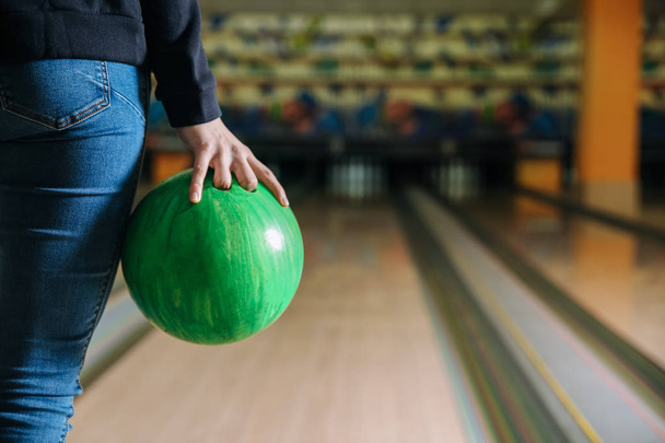 jonge vrouw spelen bowling in club - Foto, afbeelding
