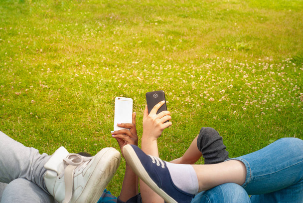 Teenage girls using mobile smart phones outdoor - Foto, afbeelding