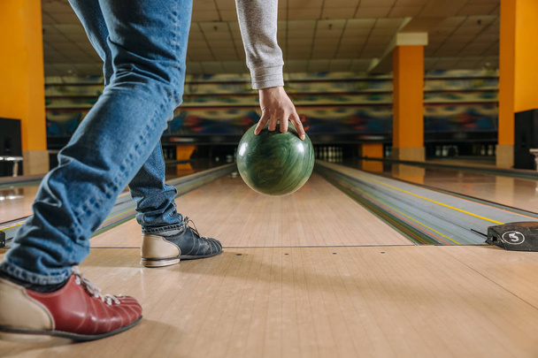 Young man playing bowling in club - Foto, afbeelding