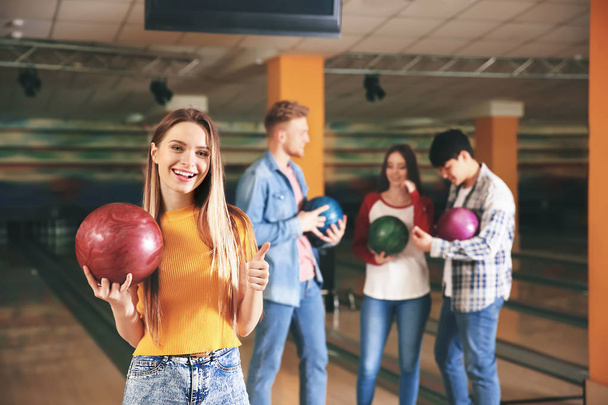 Mladá žena s přáteli v bowling klubu - Fotografie, Obrázek