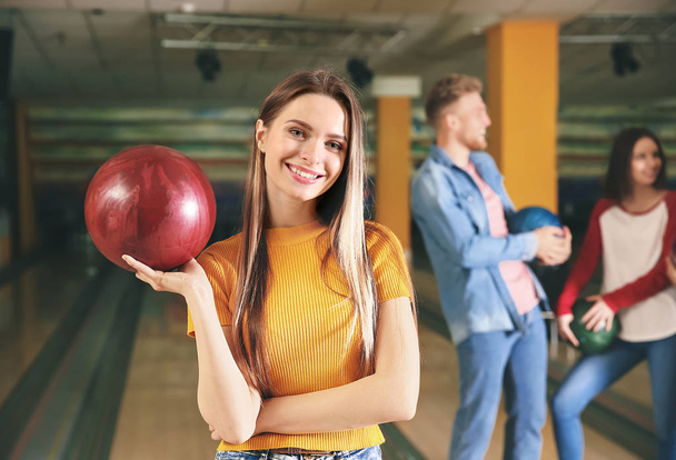 Mladá žena s přáteli v bowling klubu - Fotografie, Obrázek