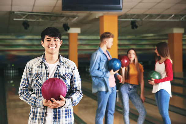 Jongeman met vrienden in bowlingclub - Foto, afbeelding