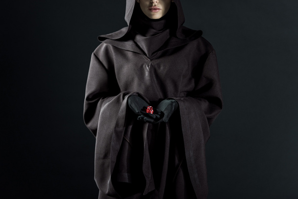 黒で隔離されたサイコロを持つ死の衣装を着た女性のトリミングされたビュー - 写真・画像