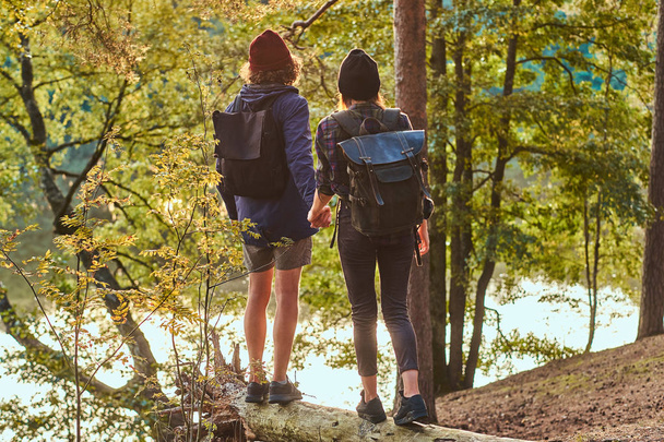 Романтична пара стоїть біля річки в зеленому яскравому лісі і дивлячись на долю
 - Фото, зображення