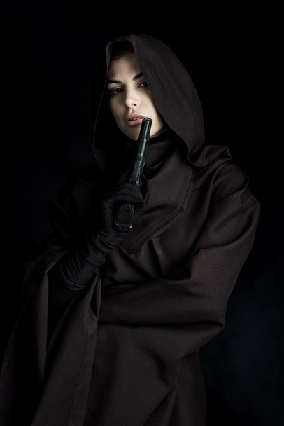beautiful woman in death costume holding gun isolated on black - Foto, imagen