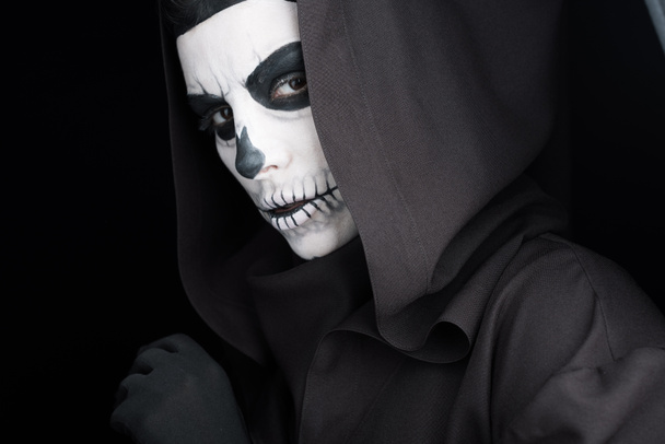 woman with skull makeup looking at camera isolated on black - 写真・画像