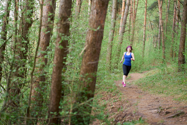 Atlética joven en zapatillas de deporte de color rosa corren en el bosque de primavera
 - Foto, imagen