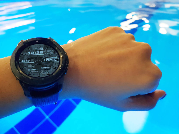 junge Frau schwimmt mit wasserdichter Smartwatch im Hallenbad. - Foto, Bild