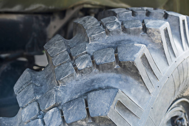 Rueda de camión grande un primer plano de neumáticos negros. Neumáticos anchos con protector profundo para coches y camiones todoterreno
 - Foto, imagen